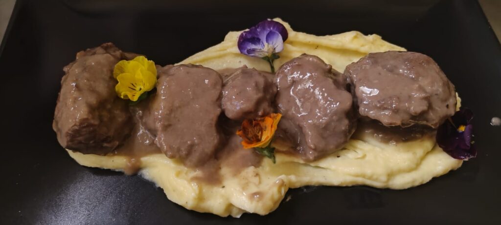 Pimienta Negra Gastrobar Carrillera al vino tinto con puré de patatas, plato estrella en Pimienta Negra Gastrobar en Valdefuentes, Cáceres